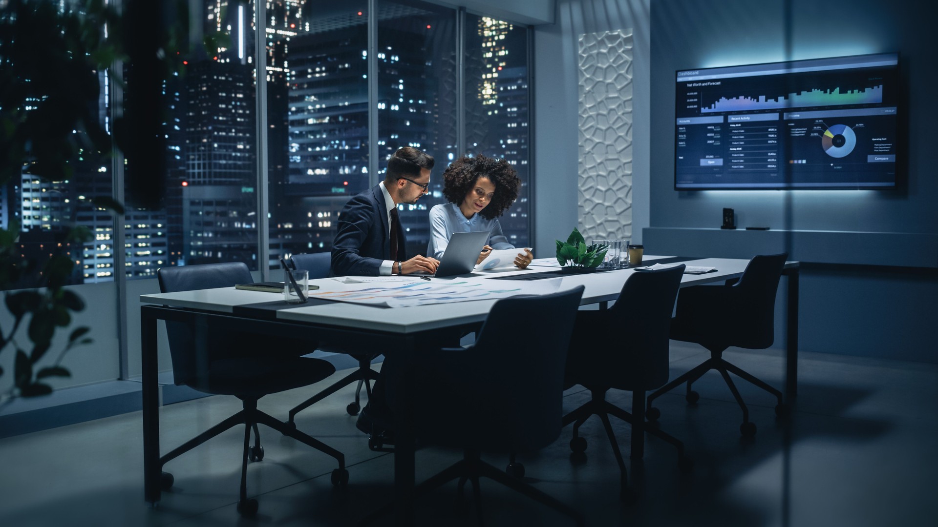 Businesspeople in Modern Office: Business Meeting of Two Managers. CEO and Operations Director Talk, Discuss, Brainstorm Corporate Strategy, Implementing Marketing and Financial Plans. Night Shift.